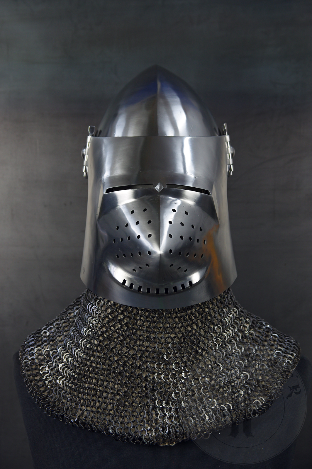 Przybica starszego typu z zason typu psi pysk wzorowana na przedstawieniu zbrojnego z otarza z Thouzon, 1410 rok, obecnie w muzeum w Luwrze. Hem wykonany z wysokiej jakoci stali niskowglowej oraz ulepszony cieplnie do 36-38 HRC./Visored bascinet based the depitc of men-at-arms from Thouzon altarpiecie (circa 1410) in Louvre Museum. Made of high quality mild steel and quenched to 36-38 HRC.